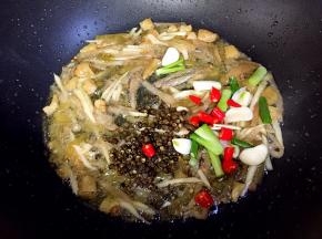 接着放入蒜，葱，小红尖椒和花椒炒香。