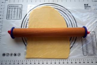 将面团装入保鲜袋，擀成5毫米厚的面片，放入冰箱冷冻10分钟变硬。