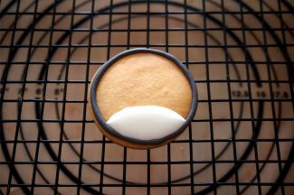 饼干下面部分用稍稀的白色糖霜（基础糖霜滴入鲜柠檬汁调制即可）填充，晾干。