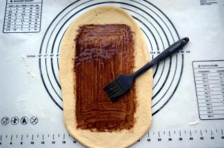 宽度确定后，往前后擀开，将面片擀薄，然后抹上一层巧克力酱。