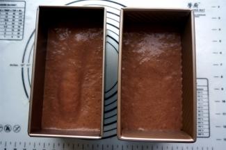 将蛋糕糊平均倒入两个吐司模中，震荡出大气泡。