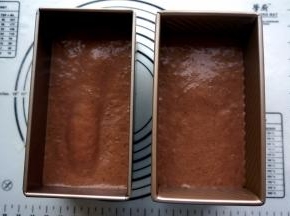 将蛋糕糊平均倒入两个吐司模中，震荡出大气泡。