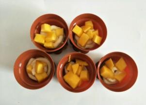 挤适量打发的奶油，放上芒果粒