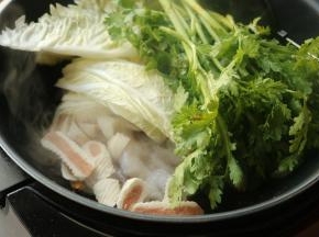 放入鲜虾、鱼肉卷，绿叶蔬菜和白菜翻炒。