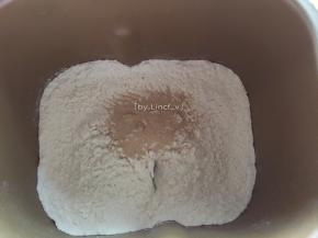 面粉倒入面包机中，加入酵母

