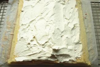 蛋糕片斜切掉两边，淡奶油抹上去，中间多一些，两边薄一点。