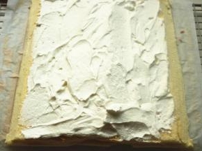 蛋糕片斜切掉两边，淡奶油抹上去，中间多一些，两边薄一点。