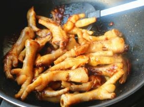 下入鸡爪翻炒，全部粘上糖色。