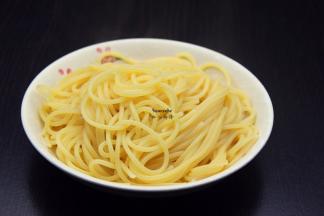 捞出意面，沥干水，放入一点油拌均；