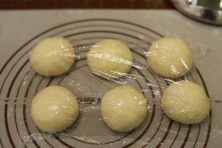 5.	将面团轻压排气后平均分成6份，盖上保鲜膜松弛20分钟