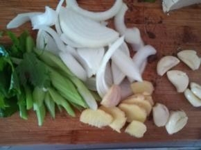 芹菜切断，洋葱切丝。生姜切片，大蒜拍扁去皮。