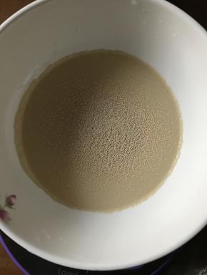 将面包粉250，细砂糖50，盐3.5克，酵母4克，鸡蛋50克，水45克，牛奶50克一起加入面包机内