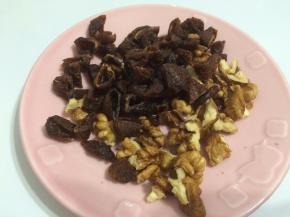 将核桃烤熟后切成小粒备用，桂圆肉也剪成小块。