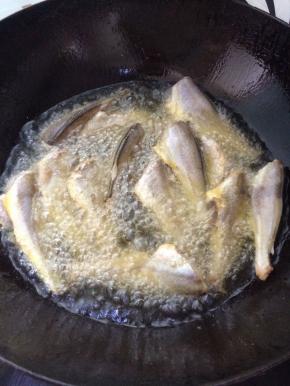 锅中放入油，烧热后，放入小黄鱼，炸至金黄色。