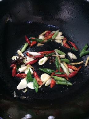 锅中放入适量油，烧热，放入葱姜蒜，辣椒，花椒，八角，翻炒均匀