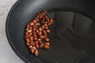 锅内倒入食用油，放入花生米，小火炸至花生微微裂开，即可关火，利用油的余温将花生炸熟。
炸好的花生捞出晾凉。