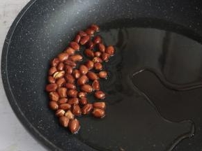 锅内倒入食用油，放入花生米，小火炸至花生微微裂开，即可关火，利用油的余温将花生炸熟。
炸好的花生捞出晾凉。