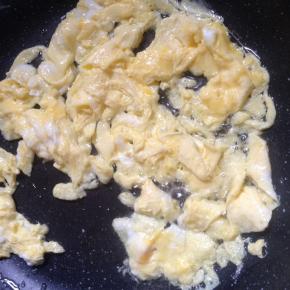 鸡蛋打散后，锅内倒入适量食用油，一边翻炒鸡蛋，一边划散。