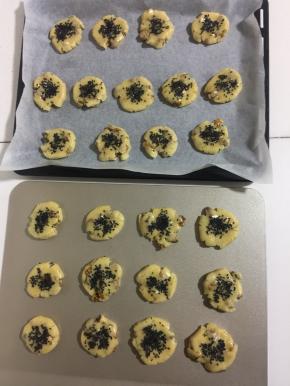 在核桃酥表面刷一层薄薄的鸡蛋液，撒上适量的黑芝麻。