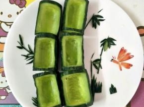 用黄瓜皮剪出叶子装饰，用煮熟的虾尾做一只蝴蝶装饰
