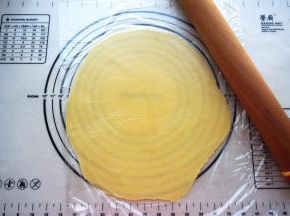 将面团放入两层保鲜纸中间，擀开成2毫米厚的圆形面片。