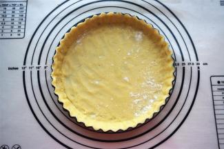 连同保鲜纸将面片压入7寸的菊花活底派盘中，放入冰箱冷藏5分钟变硬取出，撕去保鲜纸。