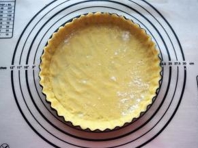 连同保鲜纸将面片压入7寸的菊花活底派盘中，放入冰箱冷藏5分钟变硬取出，撕去保鲜纸。