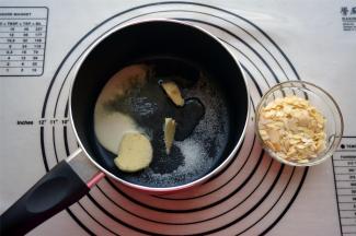 烘焙时间剩下5分钟时，开始制作焦糖牛轧糖。将淡奶油，淡味黄油，水怡，细砂糖放入奶锅中。