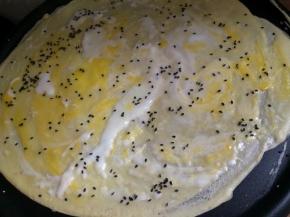 用勺子底把鸡蛋打碎，均匀的分布在面饼上