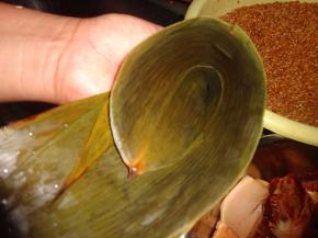 选1-2片粽叶，把这些粽叶错开折叠，即上面的粽叶压住下面粽叶一半即可。