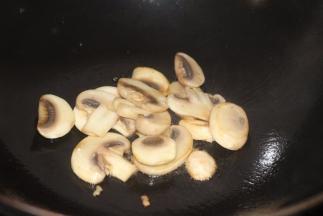 黄油入锅，加入蘑菇翻炒一下