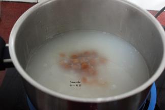 把腌制好的大米、浸泡的干贝、生姜丝倒入锅中，加入适量的清水，水煮沸之后改为小火慢慢熬30分钟