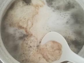 用勺子撇去浮沫。