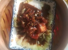 白菜叶子在盘子底部，腌好的肋排码好。