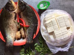 准备食材:鲫鱼2条、豆腐500g、生姜1块、小红椒2个、香菜4根、家乐浓汤宝1块、清水适量、食用油适量