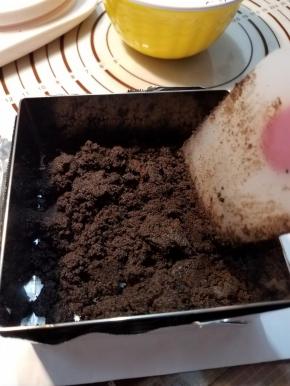 准备一张锡纸，包住慕斯圈底部，然后把搅拌好的奥利奥饼干碎倒入。