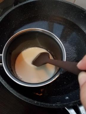 再把另一份的牛奶隔水加热，然后加入剩余的5g软化的吉利丁片，搅匀。