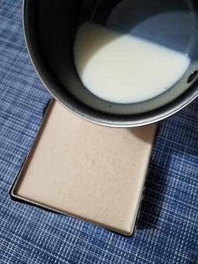 待牛奶降到手温时，取出凝固好的蛋糕，把牛奶倒入，填满慕斯圈，再次放入冰箱凝固。