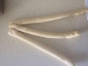 松弛好的面团搓成长条状，取三根，将顶部粘紧。