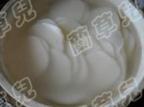 年糕切好片；用开水烫一会，沥干水分。