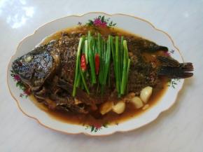 葱段、干辣椒码齐在鱼身上。起锅烧热油，趁热浇在葱段上，葱油香味四溢。