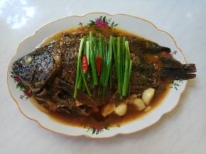 葱段、干辣椒码齐在鱼身上。起锅烧热油，趁热浇在葱段上，葱油香味四溢。