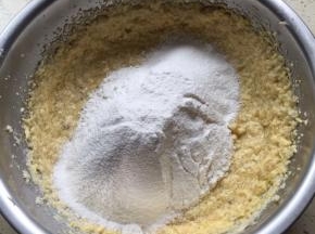 把香蕉泥加入搅拌好的黄油中，搅拌均匀，加入过筛的低籺和泡打粉，用刮刀由底向上，顺时针翻拌均匀；