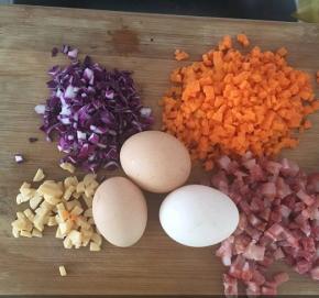 胡萝卜，紫甘蓝，腊肠，鳕鱼肠切丁。鸡蛋打入碗中，搅散。