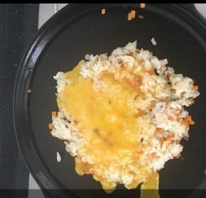 米饭受热均匀后，倒入鸡蛋液。这样鸡蛋液可以包裹每粒米饭。