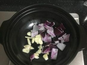 砂锅凉油，放入大蒜和洋葱煸香。