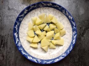 盘底铺上土豆（也可以铺南瓜、红薯，也可以不铺）。