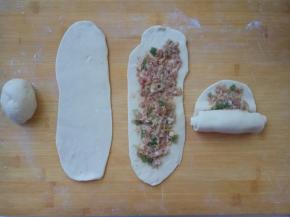 面剂擀成牛舌状，一边向上拉一拉面，一边均匀地抹一层肉馅，再从下向上卷好。