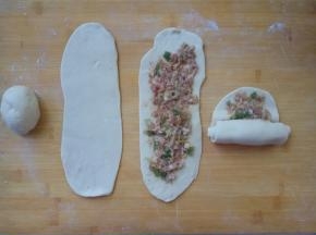 面剂擀成牛舌状，一边向上拉一拉面，一边均匀地抹一层肉馅，再从下向上卷好。