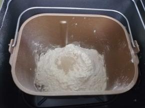 将水，鸡蛋，白砂糖，盐，高筋面粉，酵母等按顺序放入面包机桶中启动程序。和面两次后加入室温软化的黄油，再次和面一次。